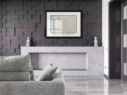 An archival 1880 map of North Williamsburg, Brooklyn, featured in a solid black oak frame. The vintage New York architectural print hangs on a dark 3D accent wall above a minimalist concrete mantle and a light grey textured couch.