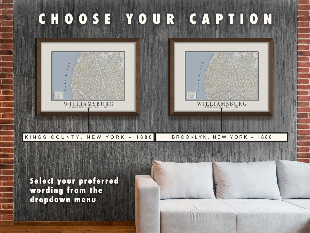 Two horizontal framed prints of a restored 1880 Williamsburg cartography map hanging side by side above a living room sofa. Header text reads 'CHOOSE YOUR CAPTION' with leader lines connecting to enlarged boxes displaying the two title options: 'KINGS COUNTY, NEW YORK - 1880' and 'BROOKLYN, NEW YORK - 1880', instructing shoppers to pick their preferred variation from the dropdown.